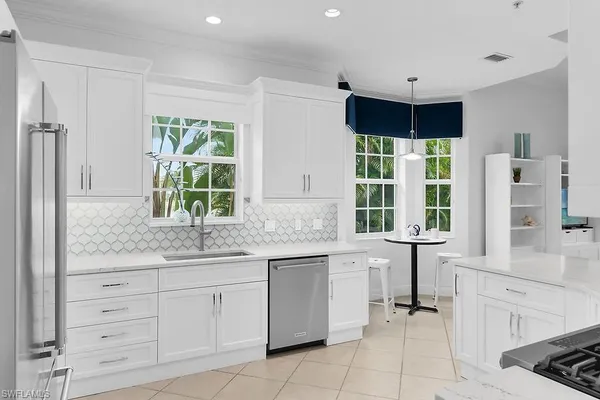 a kitchen with granite countertop white cabinets and a window
