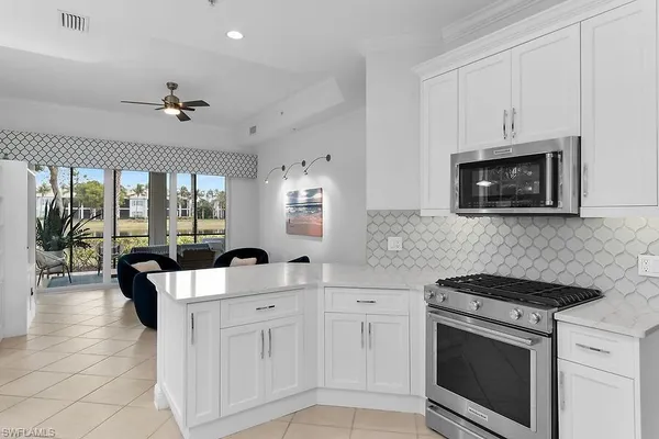 a kitchen with stainless steel appliances granite countertop a stove a sink and a microwave