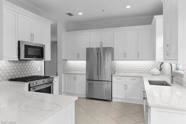 a kitchen with stainless steel appliances granite countertop a refrigerator sink and stove