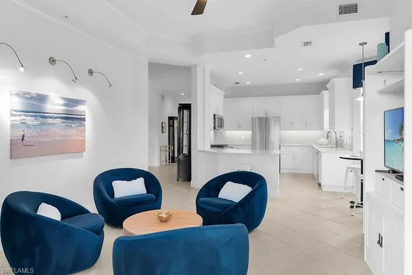 a living room with furniture kitchen view and a chandelier