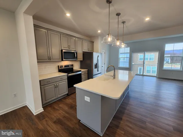 a kitchen with wooden floors and stainless steel appliances