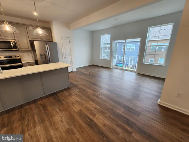 a view of a kitchen with furniture and wooden floor