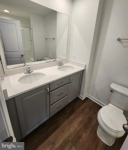 a bathroom with a granite countertop sink toilet and mirror