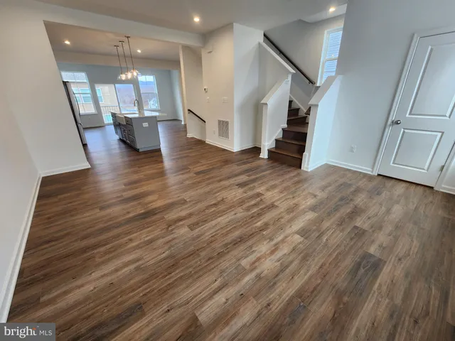 a view of a living room with wooden floor and a large window