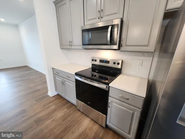 a kitchen with granite countertop wooden cabinets and a stove top oven