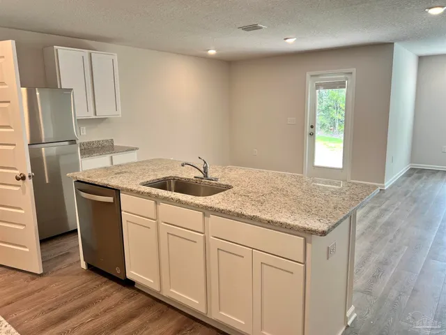 a kitchen with a sink a refrigerator and window
