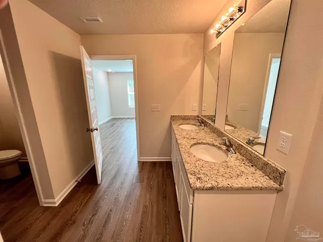 a bathroom with a granite countertop sink a mirror and shower