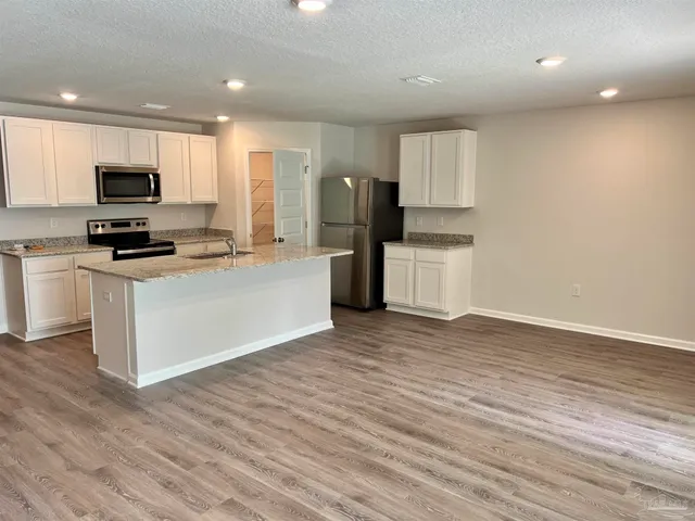 a kitchen with a stove a refrigerator and a microwave