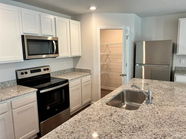a kitchen with a sink stove and refrigerator