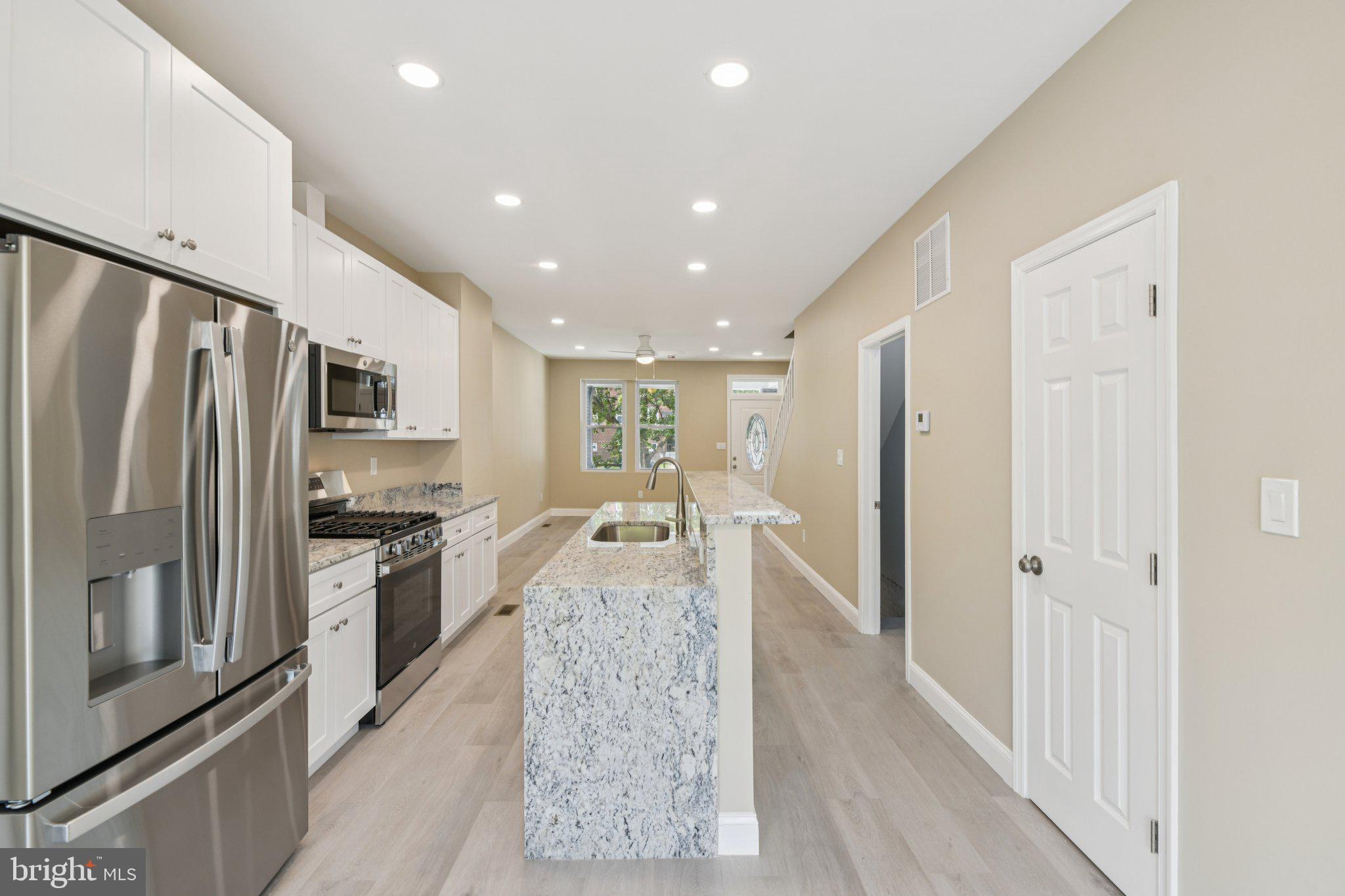 729 Madison Street Northwest Washington, DC 20011 - Photo 11 of 59 a large kitchen with granite countertop a large counter top stainless steel appliances and cabinets