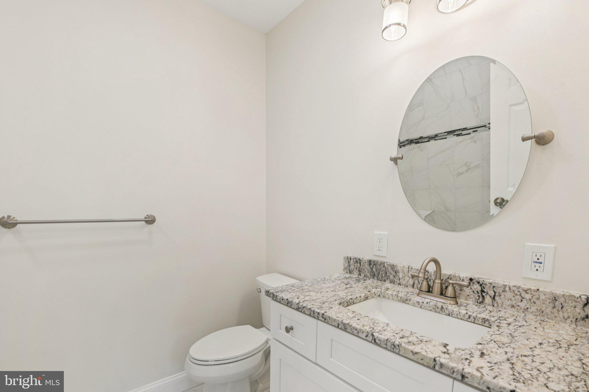 729 Madison Street Northwest Washington, DC 20011 - Photo 23 of 59 a bathroom with a granite countertop sink a toilet and a mirror