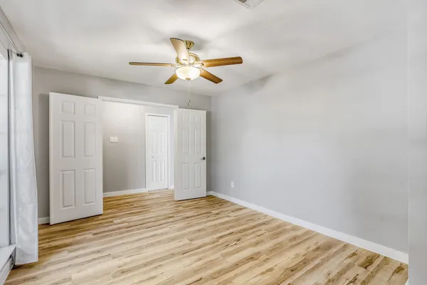 a view of a bedroom with wooden floor and bathroom