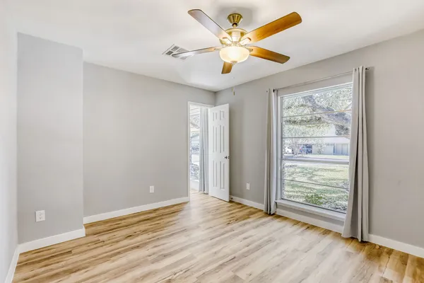 a view of a room with wooden floor and a ceiling fan