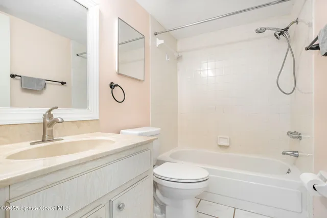 a bathroom with a granite countertop sink a toilet and shower