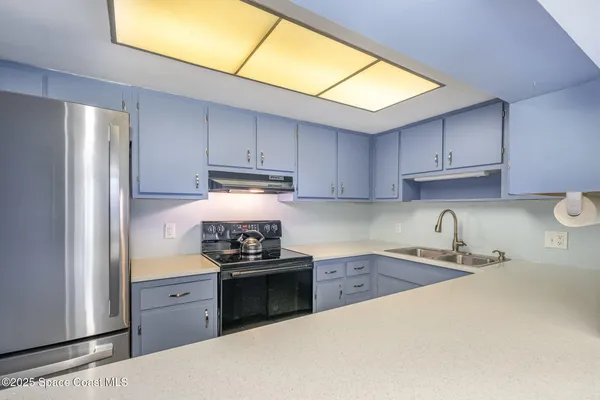 a kitchen with granite countertop a sink stainless steel appliances and cabinets
