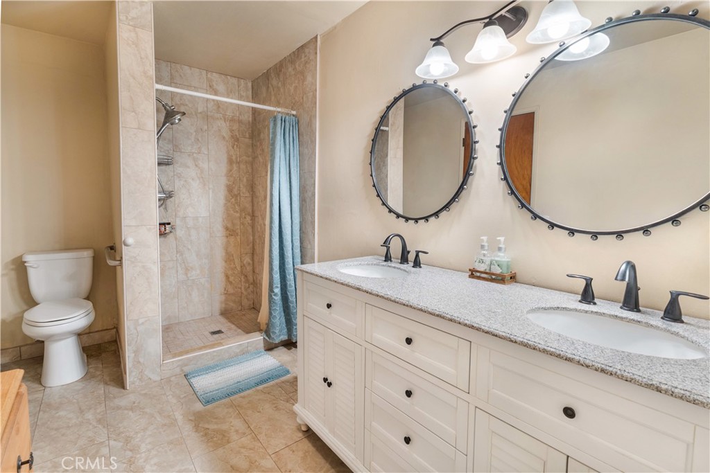 766 South 6th Street Grover Beach, CA 93433 - Photo 17 of 20 a bathroom with a granite countertop sink mirror and toilet
