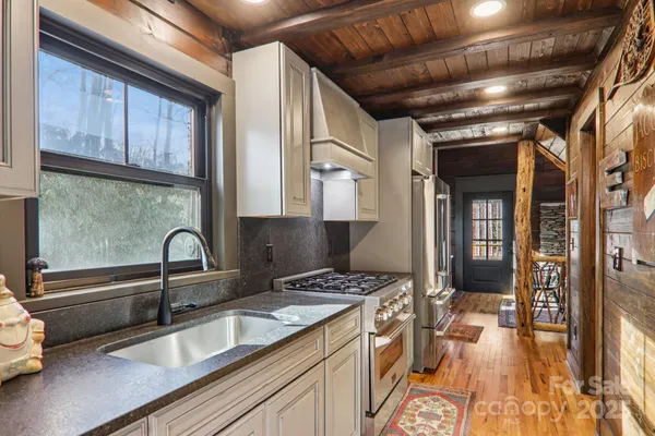 a kitchen with granite countertop a sink stainless steel appliances and cabinets