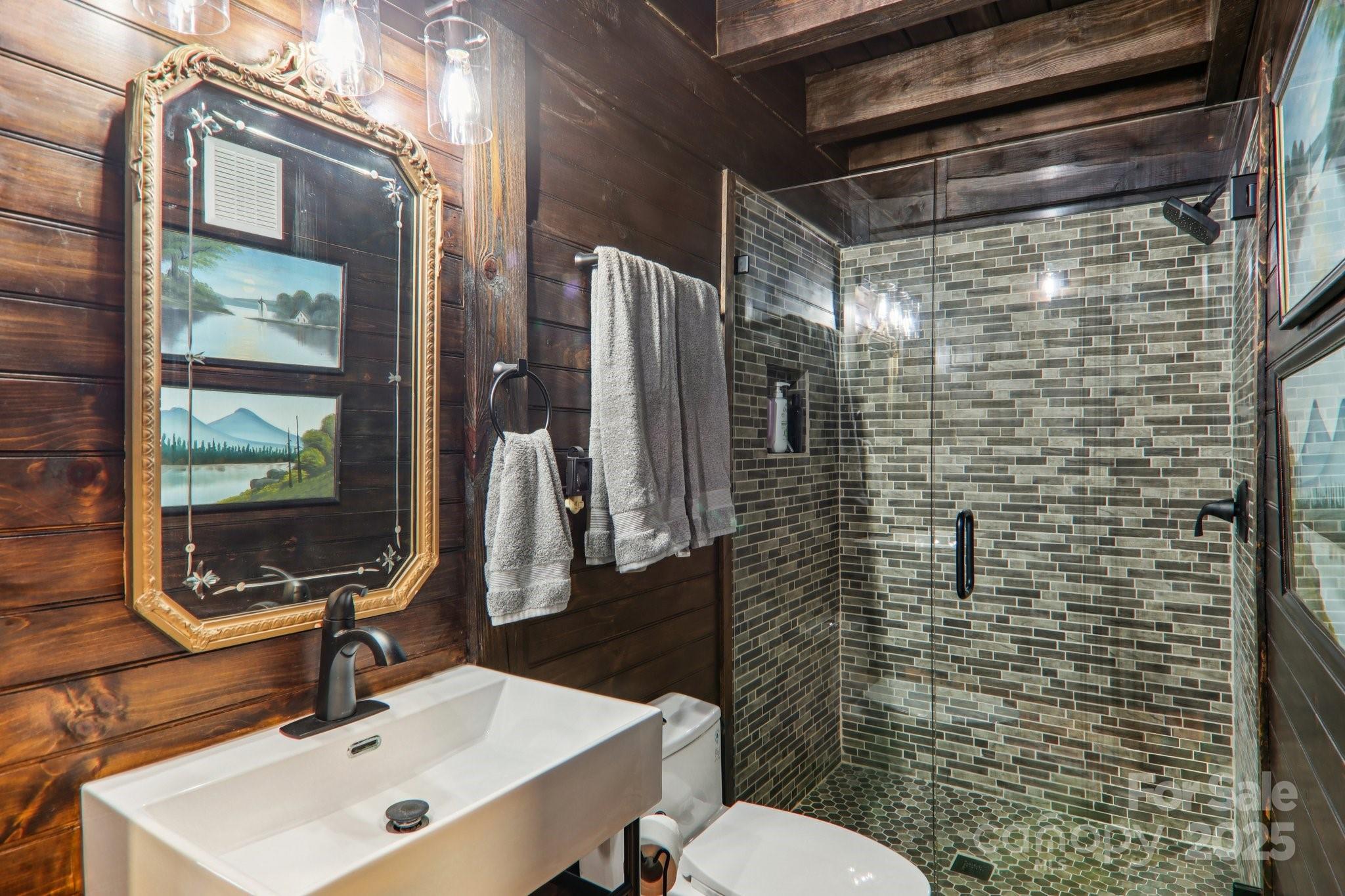 408 Little Elbow Mountain Road Lake Toxaway, NC 28747 - Photo 17 of 48 a bathroom with a sink toilet and shower