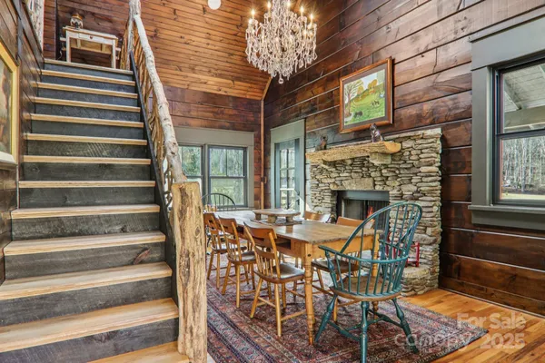 a dining room with furniture a fireplace and wooden floor