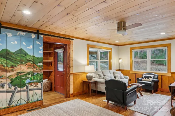 a living room with furniture a flat screen tv and large window