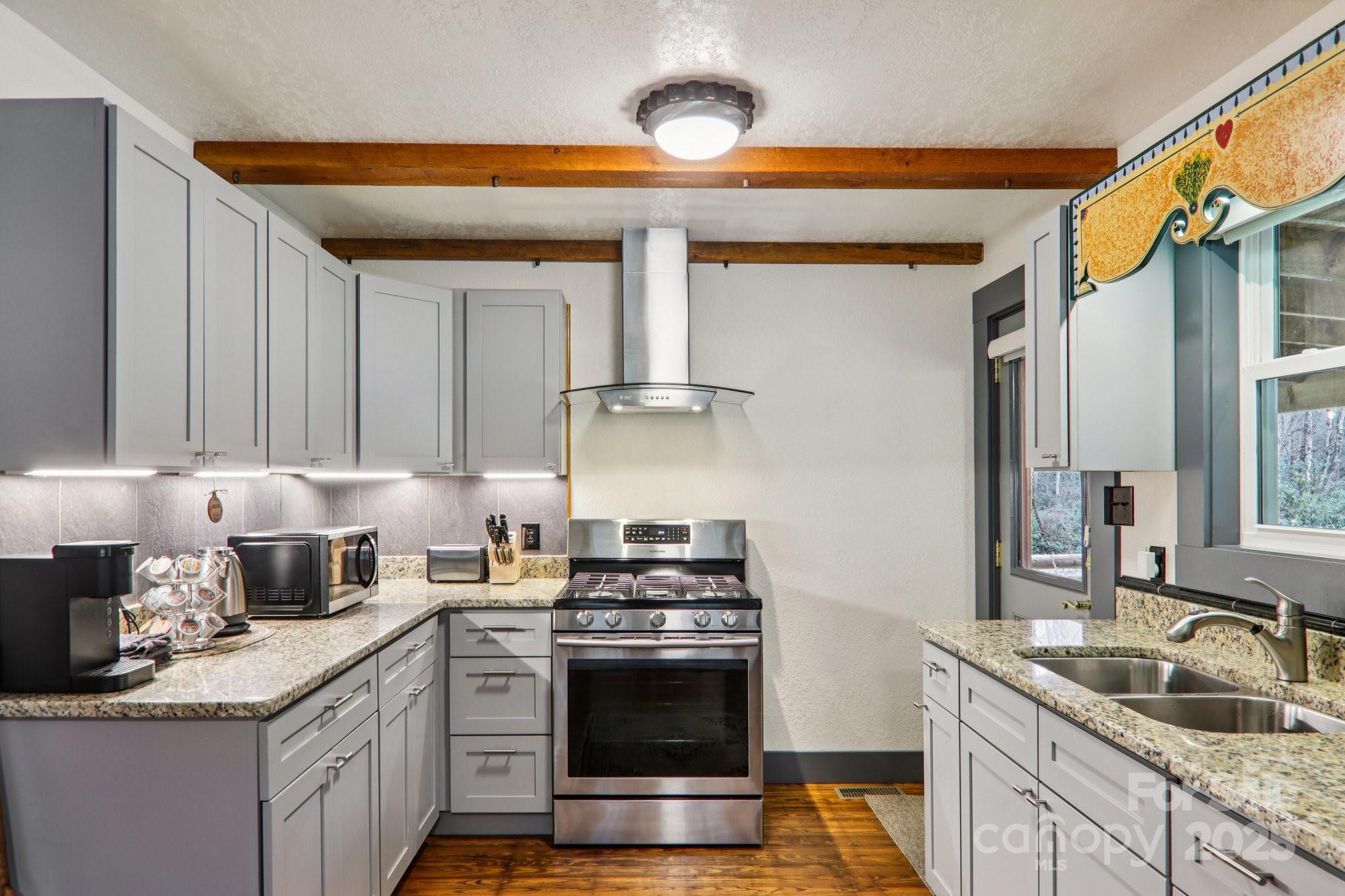 408 Little Elbow Mountain Road Lake Toxaway, NC 28747 - Photo 41 of 48 a kitchen with granite countertop a sink stainless steel appliances and cabinets