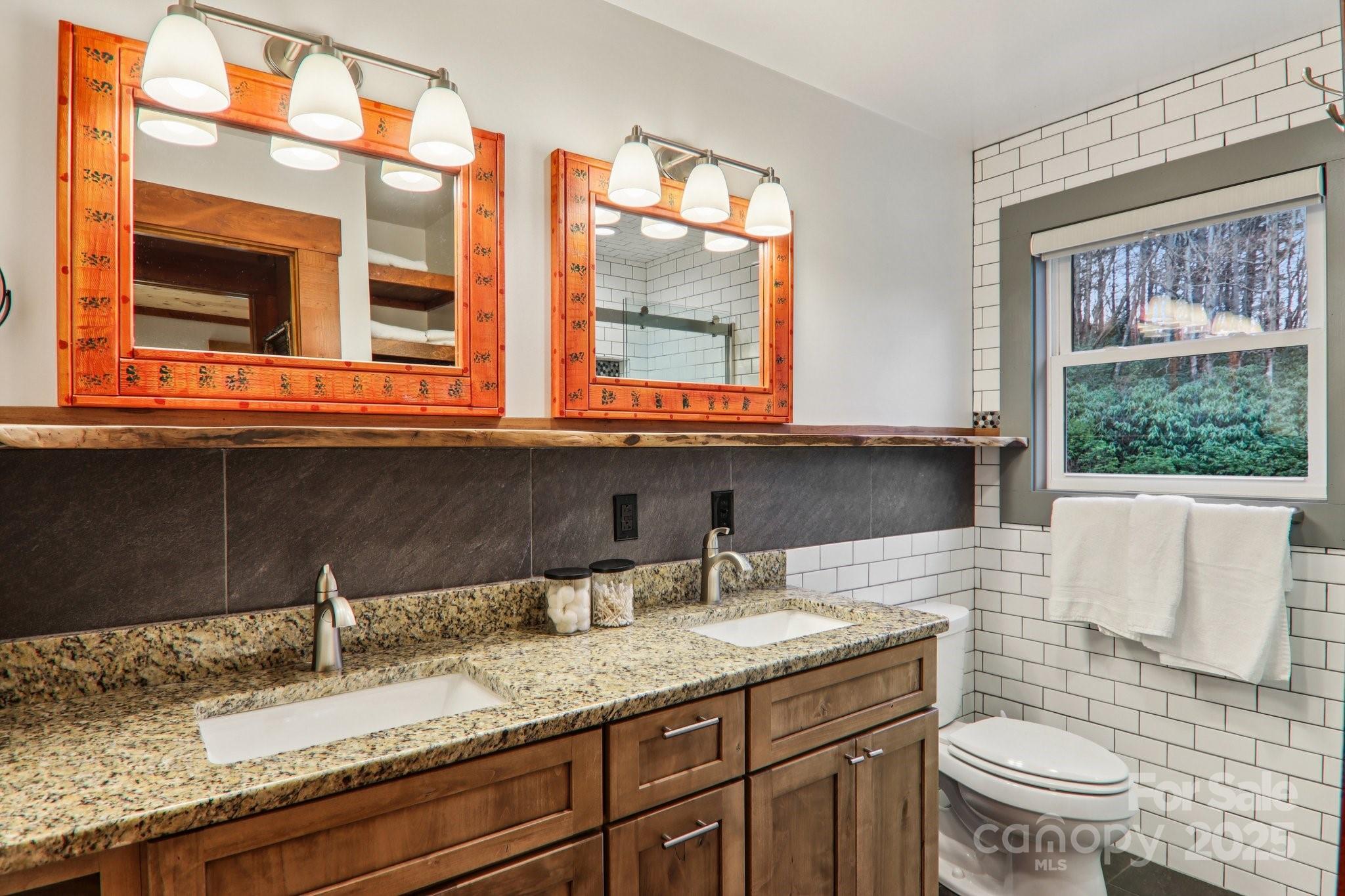 408 Little Elbow Mountain Road Lake Toxaway, NC 28747 - Photo 45 of 48 a bathroom with a granite countertop sink and a large mirror