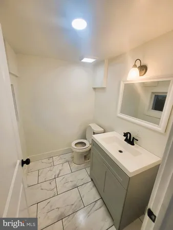a bathroom with a sink a toilet and mirror