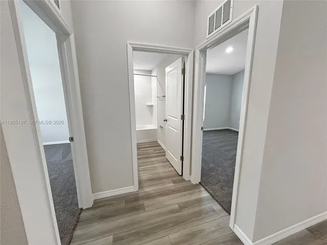a view of a hallway with wooden floor
