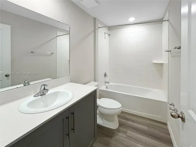 a bathroom with a sink toilet a mirror and shower