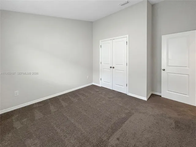 a view of an empty room and closet area