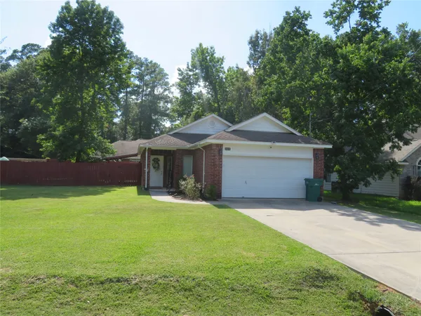 a front view of a house with yard and green space