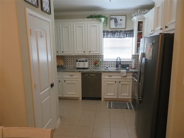 a kitchen with stainless steel appliances a refrigerator sink and cabinets