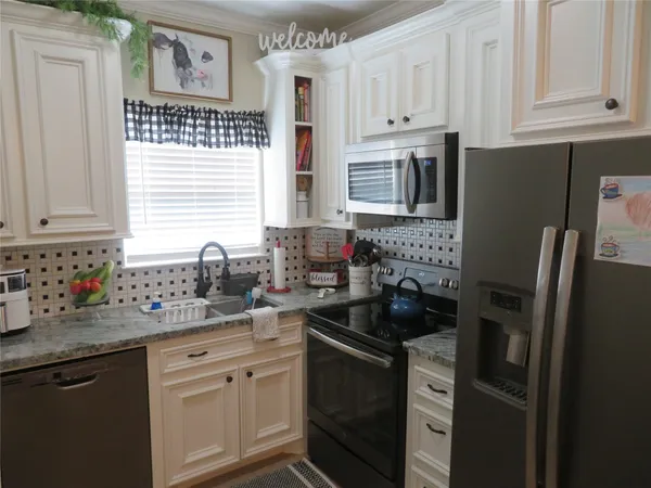 a kitchen with stainless steel appliances granite countertop a refrigerator sink and stove