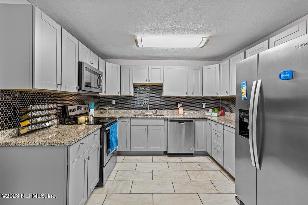 8490 Walden Road Jacksonville, FL 32244 - Photo 14 of 34 a kitchen with a refrigerator sink and cabinets