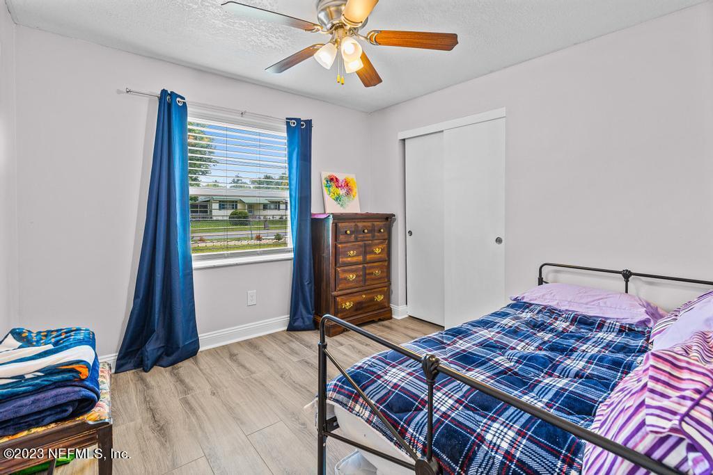 8490 Walden Road Jacksonville, FL 32244 - Photo 20 of 34 a bedroom with a bed and a chandelier