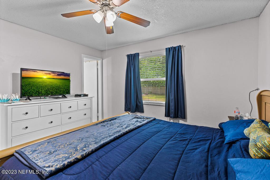 8490 Walden Road Jacksonville, FL 32244 - Photo 22 of 34 a bedroom with a bed and a flat screen tv