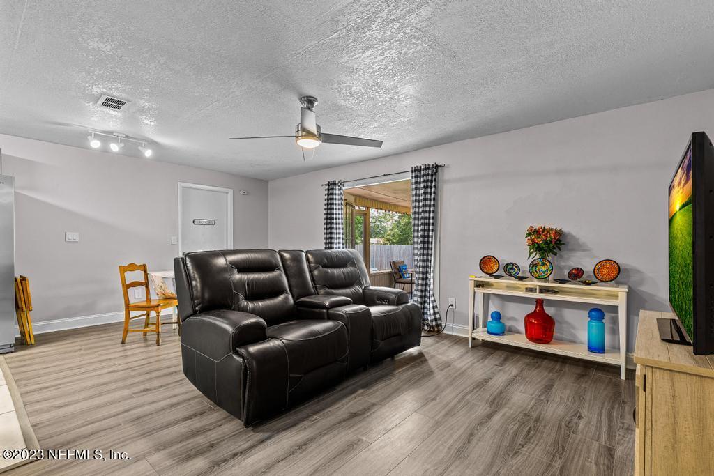 8490 Walden Road Jacksonville, FL 32244 - Photo 8 of 34 a living room with furniture and a flat screen tv