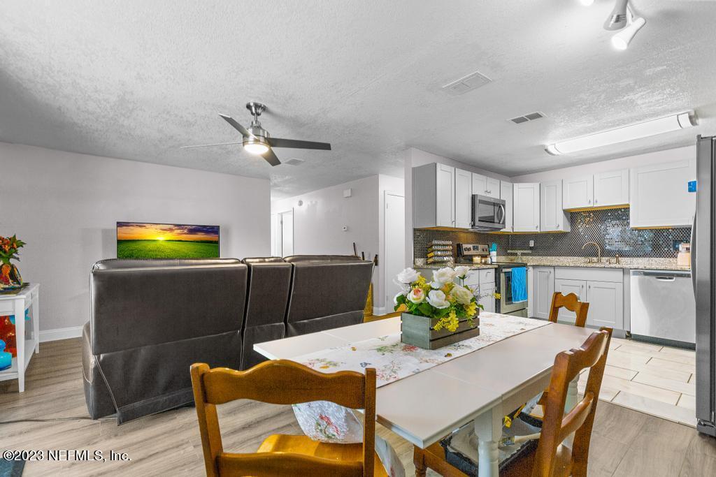 8490 Walden Road Jacksonville, FL 32244 - Photo 10 of 34 a kitchen with stainless steel appliances granite countertop a dining table chairs and granite counter tops