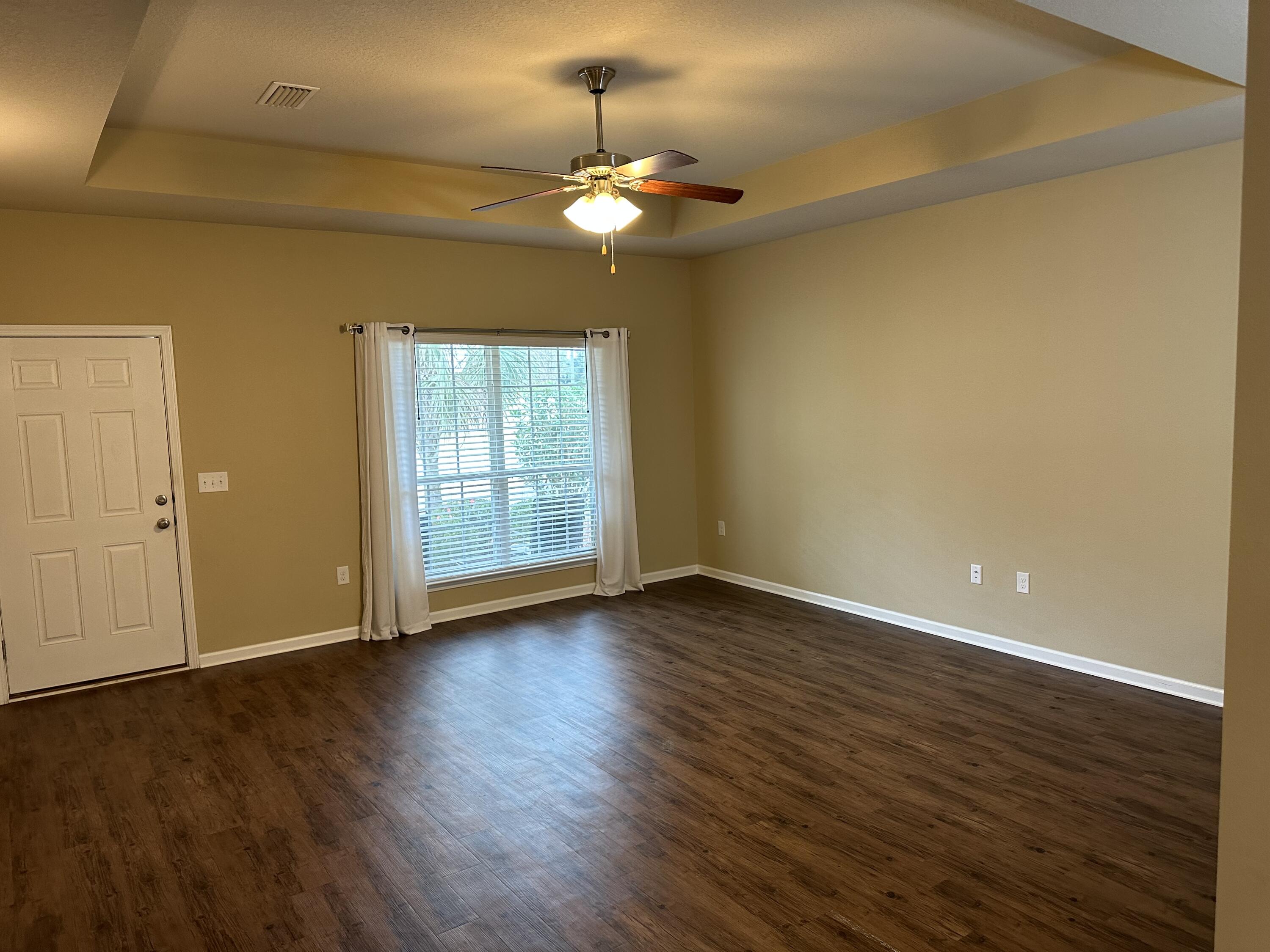 260 Cornelia Street Freeport, FL 32439 - Photo 3 of 31 a view of an empty room with wooden floor and a window