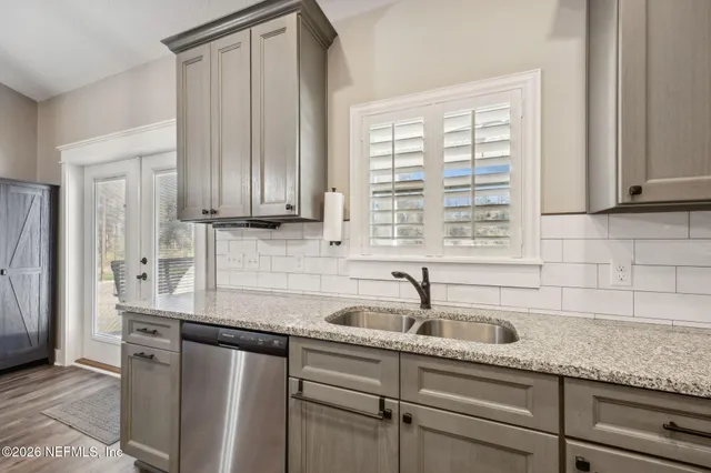 a kitchen with stainless steel appliances granite countertop a sink a refrigerator and window