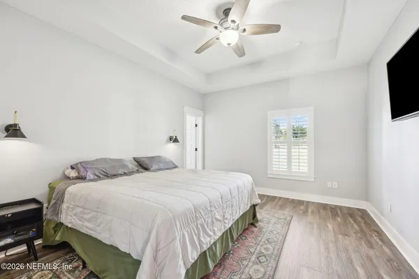 a bedroom with a large bed and a flat tv screen on dresser