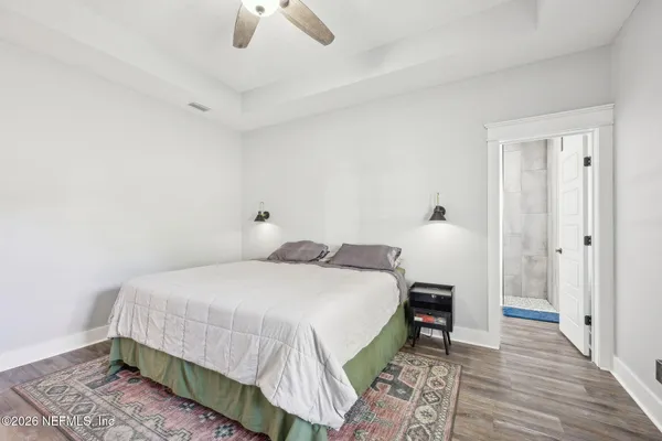 a bedroom with a bed and wooden floor