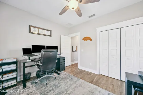 a view of a hallway with wooden floor and entryway