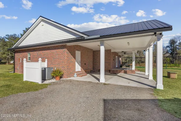 a view of house with a big yard and large trees