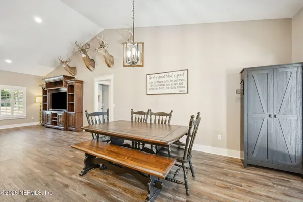 a dining room with furniture a chandelier and wooden floor