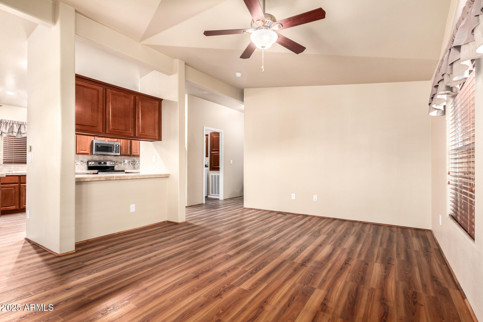 2929 East Main Street, Unit 159 Mesa, AZ 85213 - Photo 4 of 30 a view of a kitchen with wooden floor and a ceiling fan