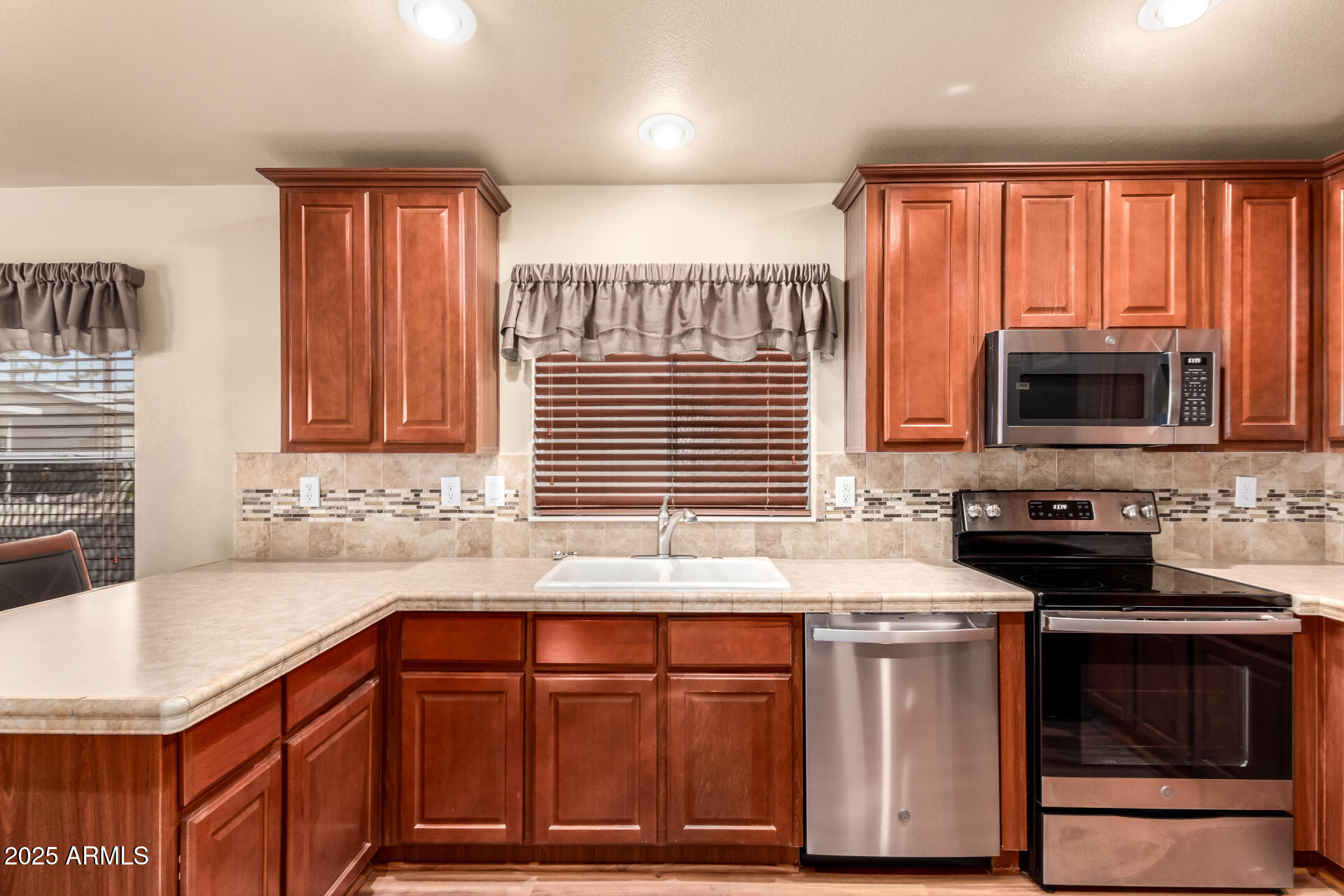 2929 East Main Street, Unit 159 Mesa, AZ 85213 - Photo 7 of 30 a kitchen with stainless steel appliances wooden cabinets a sink and a stove