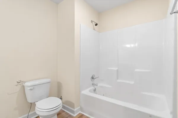 a white toilet sitting next to a bath tub