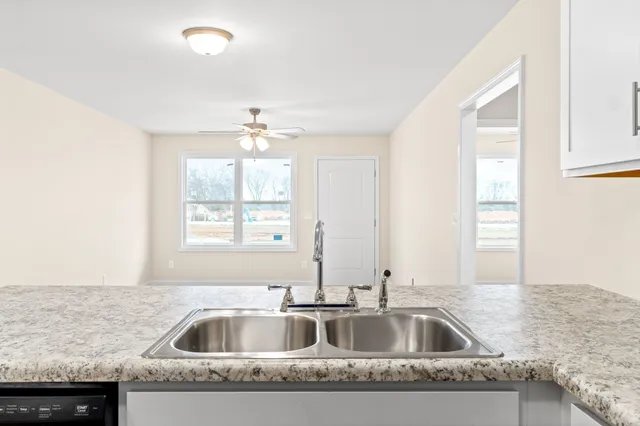 a kitchen with granite countertop a sink and a window