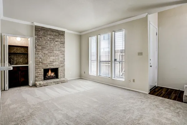 a view of an empty room with a window and fireplace
